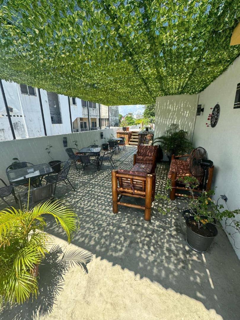Shaded patio with tables and wooden chairs